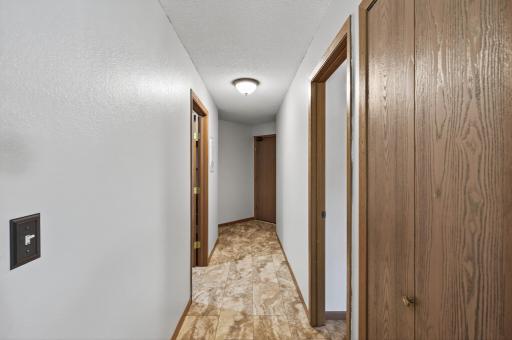 Looking from the dining room to the main entry door you will notice a coat/storage closet on the right. The next door on the right is the primary bedroom and en suite and to the left is the laundry and utility room.