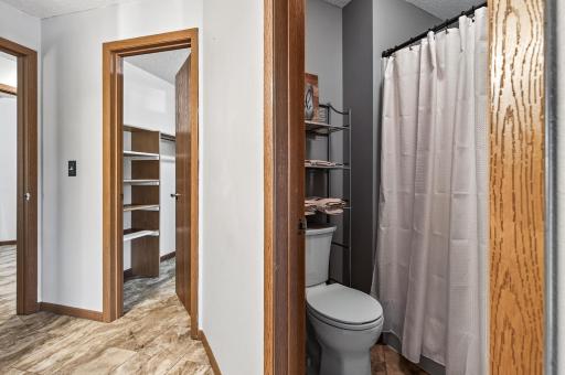 There is a private shower and toilet room in the primary bathroom. The beautiful luxury vinyl tile flooring runs throughout the space in the primary en suite.