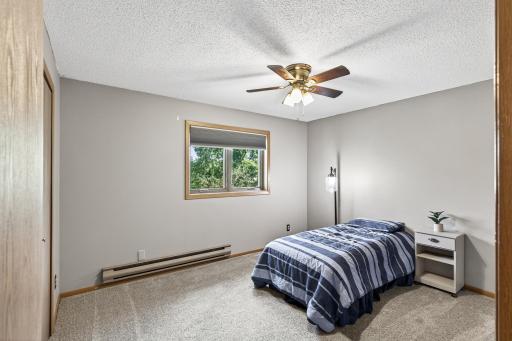 The second bedroom is just off the dining room and features newer carpet, a ceiling fan, and a new Anderson window.