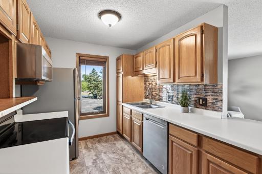 This fantastic kitchen features newer stainless steel appliances, luxury vinyl tile flooring, and a generous amount of counter and cabinet space.