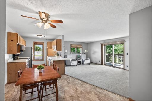 The kitchen, dining room, and living room flow together seamlessly. There is a breakfast bar on the counter between the kitchen and living room perfect for a quick snack or setting up a buffet for entertaining.