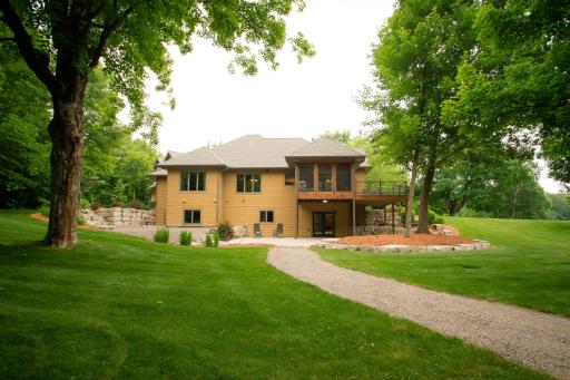 Gravel walkway from back of home leads to detached garage, sauna, and concrete pad