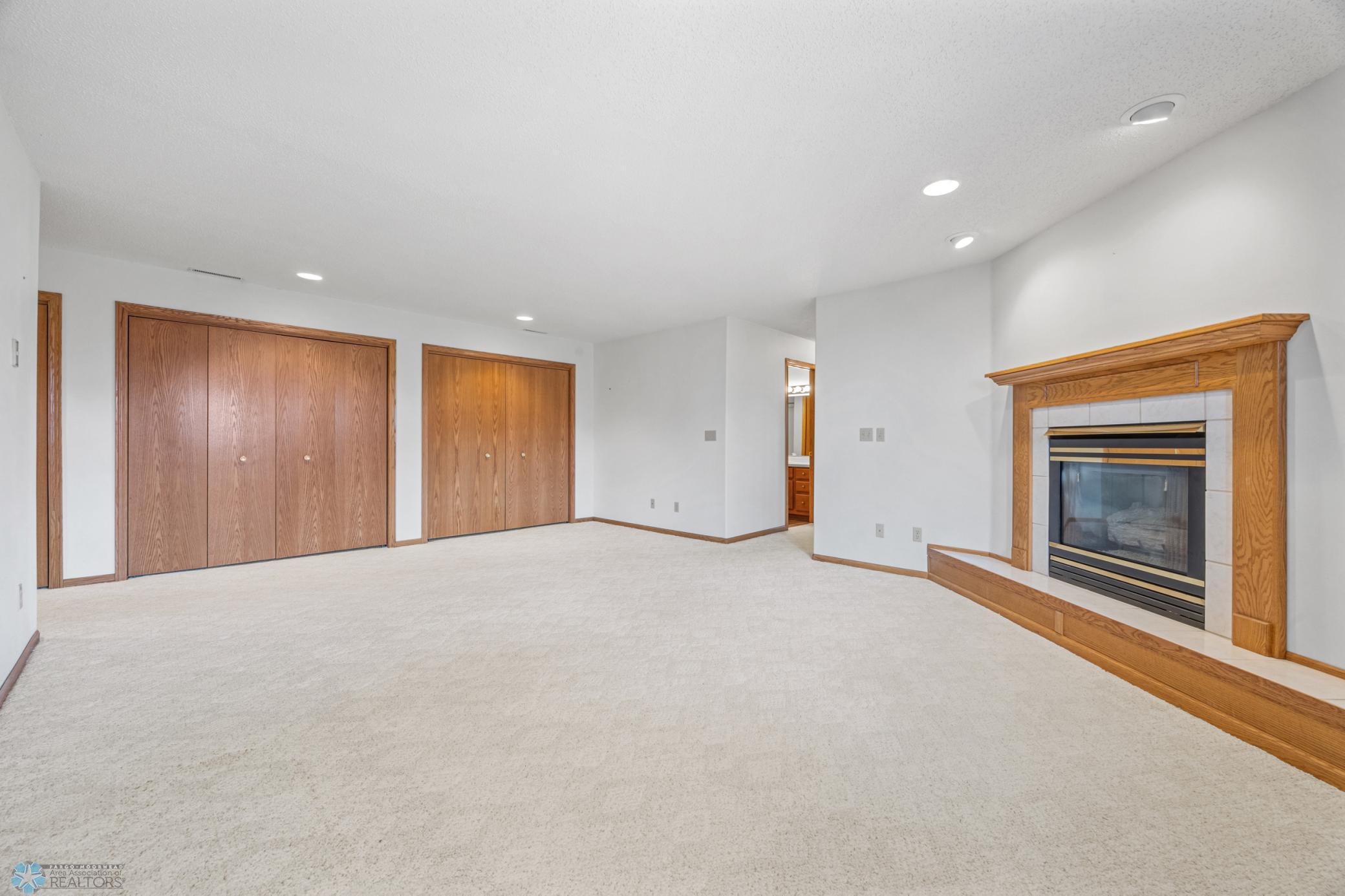 Light and bright! Lower level Family Room with gas fireplace, large windows and TONS of storage.
