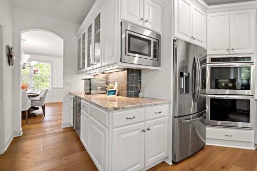 An alternative view from the kitchen offers a clear sightline to the formal dining room, emphasizing the homeâs elegant flow and perfect setup for sophisticated gatherings.