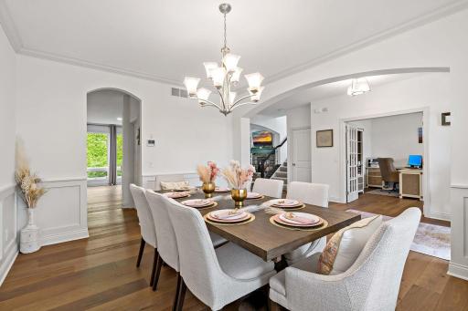 The dining room features beautiful archways and elegant wainscoting, adding timeless architectural charm and sophistication to every meal and gathering.â