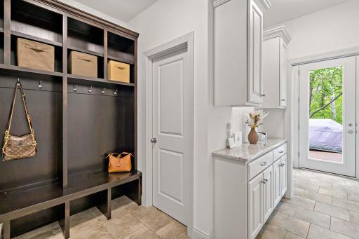 The mudroom is designed for convenience and organization, featuring a drop zone, custom built-in bench, and a spacious walk-in closetâperfect for keeping daily essentials neatly tucked away.