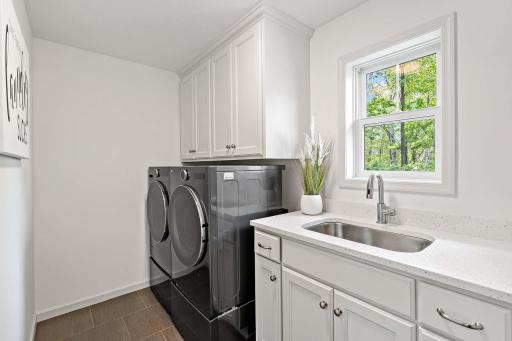 The upper-level laundry room has been thoughtfully updated with a new sink, faucet, and countertop, along with a brand-new washer and dryer set on pedestalsâoffering enhanced functionality, comfort, and style.