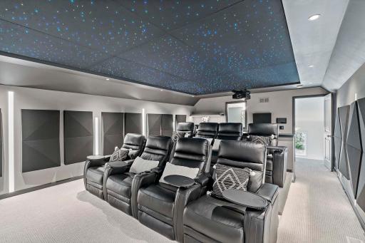 Relax in 8 motorized recliners with LED cupholders, USB chargers, and tray tables, or enjoy high-top bar seating for 4. A dry bar with commercial Uline beverage cooler, Control4 iPad remote, and Lutron lighting control enhance the experience.