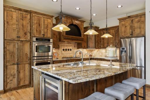 Rich alder wood custom cabinetry features both under-counter and over-cabinet lighting, adding function, warmth and elegance to the kitchen.