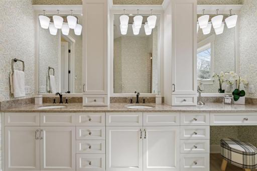 The primary bath was fully renovated last year and features a unique, elegant design detail: triple vanity mirrorsâtwo above the dual sinks and a third above the built-in makeup desk.