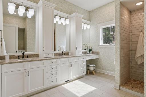 Recently updated, the primary bath features enameled cabinetry and beautiful decor, stone and tile work, plus heated floors.