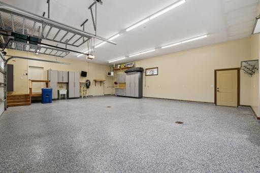 Conveniently located off the kitchen, the heated garage features a washtub, high-end cabinetry, and epoxy floors with floor drains. With tall ceilings, extra storage racks. Measuring nearly 30x40, it can accommodate four to five cars comfortably.