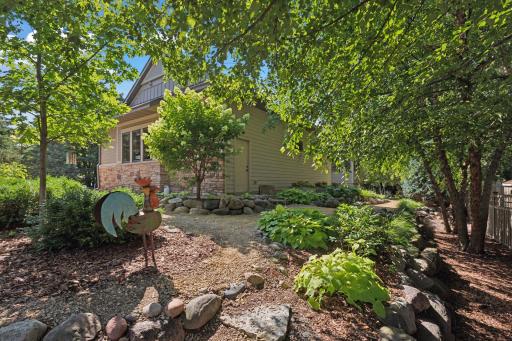 Natural stone boulders serve as border to the winding pathways that meander through vibrant perennial gardens all around the property.
