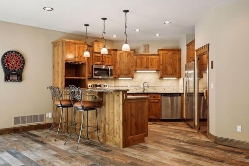 Entertaining is made easy with the kitchenette, featuring full-sized appliances and bar seating that offers an ideal serving area, complemented by ample counter space. There is a full size refrigerator, oven, microwave and dishwasher.