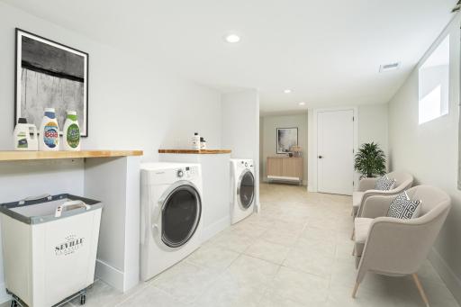 Lower Level Laundry space and mud room. Plumbed for standard washer dryer. Virtually staged. The pictured set of laundry machinery is virtual - shown for placement and rough-in access.