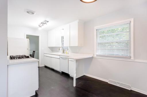 Updated kitchen with crisp white cabinetry, modern lighting, and ample counter space.