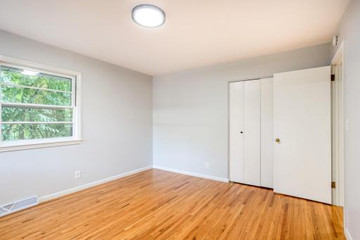 Bright and airy primary bedroom with ample closet space and fresh neutral finishes.