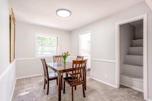 Formal dining room with brand-new carpet and bright window, ideal for hosting meals and gatherings.
