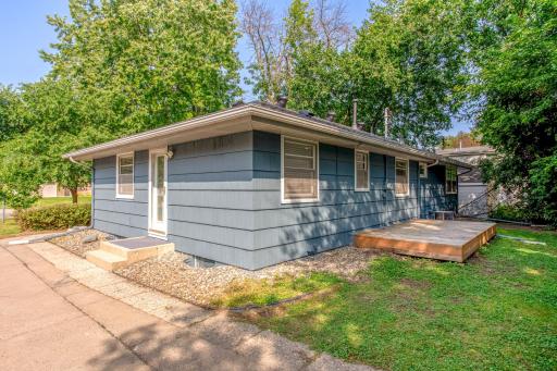 The side entrance opens onto a spacious backyard with simple landscaping and low-maintenance rock beds.
