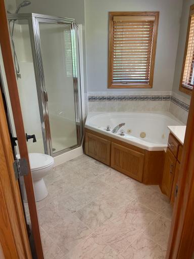 Primary Bathroom with shower, jetted tub and marble flooring