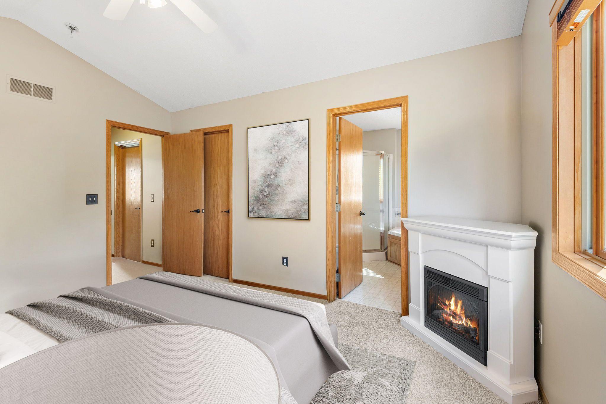 Primary Bedroom with electric fireplace and ensuite- virtually staged