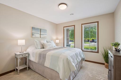 Located at the front of the home, this guest bedroom is filled with natural light and offers privacy from the primary suite.