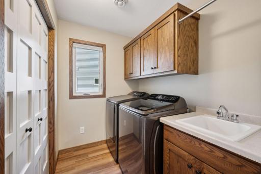 Laundry room with upper cabinets and a utility sink for added convenience.