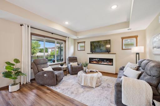 The living area offers a warm ambiance, centered around the fireplace and filled with natural light. The in-floor heat will provide extra warmth during colder months.