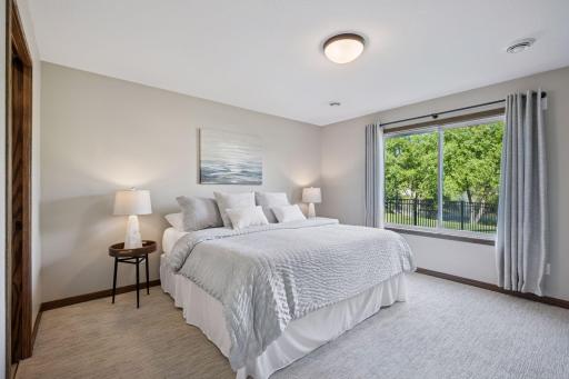 The primary bedroom features neutral tones, ample room for furniture, and direct access to the ensuite bathroom. This serene retreat is situated at the back of the home, featuring large windows that overlook the fenced yard.