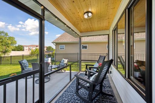 Relax in this screened porch with wood ceiling detail and views of the patio and yard.