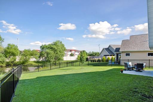 There is plenty of green space in this backyard that gently slopes down to the pond.