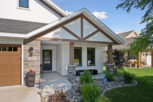The covered front entry, featuring decorative beams and stone columns, offers wonderful curb appeal and is perfect for seasonal dÃ©cor.