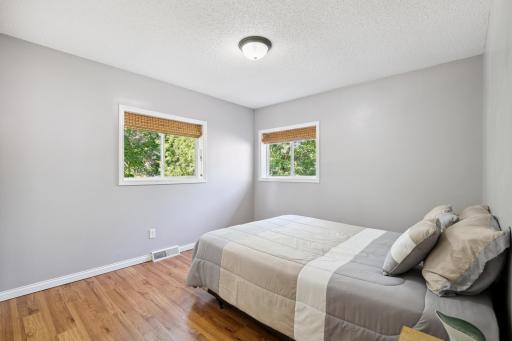 2nd Bedroom featuring generous windows wood flooring and walk in closet