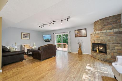 Beautiful wood finished floors with a fireplace and deck off the side.