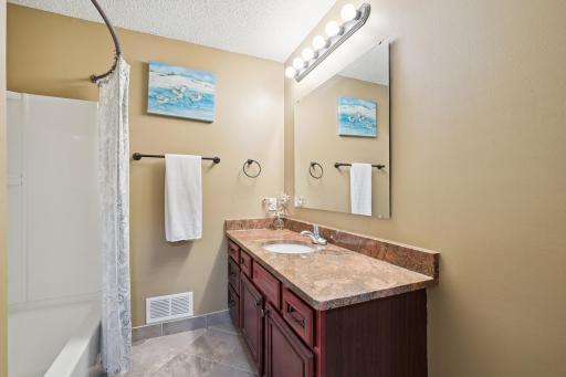 Main bathroom on the upper level featuring granite countertops and shower