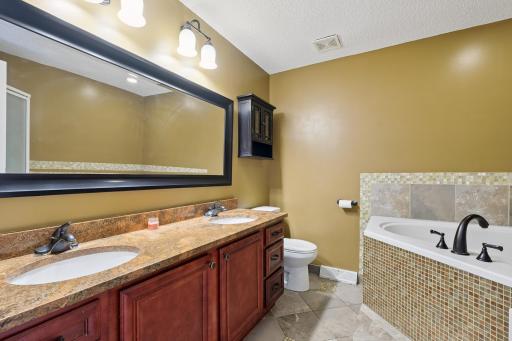 On-suite bathroom with double sinks and jacuzzi tub.