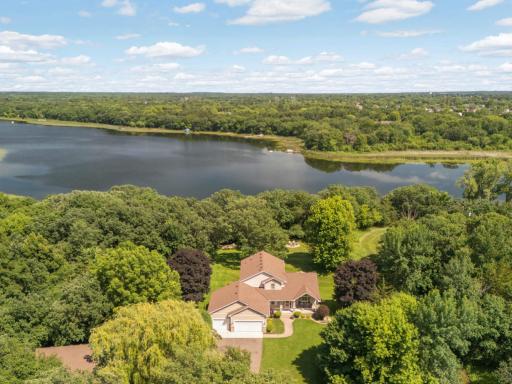 Breathtaking drone view captures the perfect harmony of lakefront living — this stunning home nestled on the shoreline offers panoramic views of the water, private dock access, and peaceful natural surroundings.