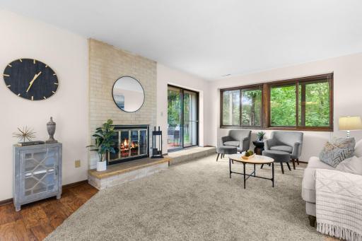 Welcome to 1849 Yuma Ln N! Living room features large windows that offer plenty of natural light and wooded views
