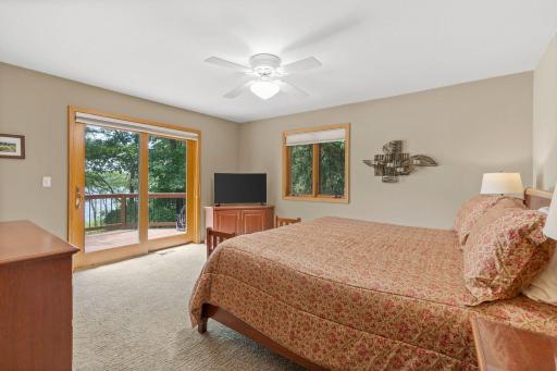 Primary suite overlooking the lake with walk-in closet and large bathroom with soaking tub.
