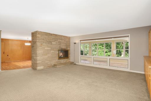 Stunning double sided stone fireplace divides the main floor living room and dining room.