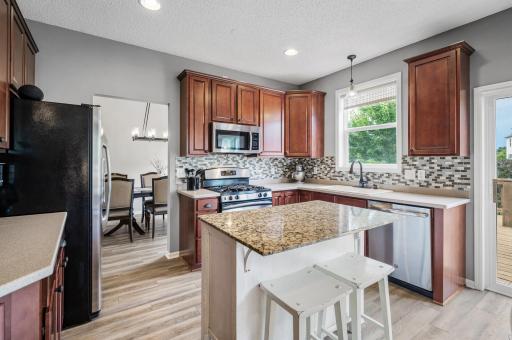Kitchen features maple cabinetry, solid surface counters, tile backsplash and stainless steel appliances. Island is not attached