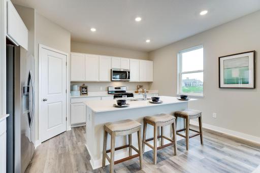 Spacious kitchen with tons of cabinets and plenty of seating around the island for everyone. Model picture shown. Colors and finishes may vary.