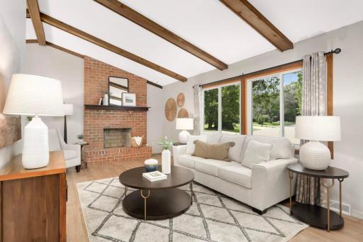 Vaulted living room with beams on the ceiling and wood burning fireplace! NOTE: the wood burning fireplace hasn’t been used by current owners (30 years).