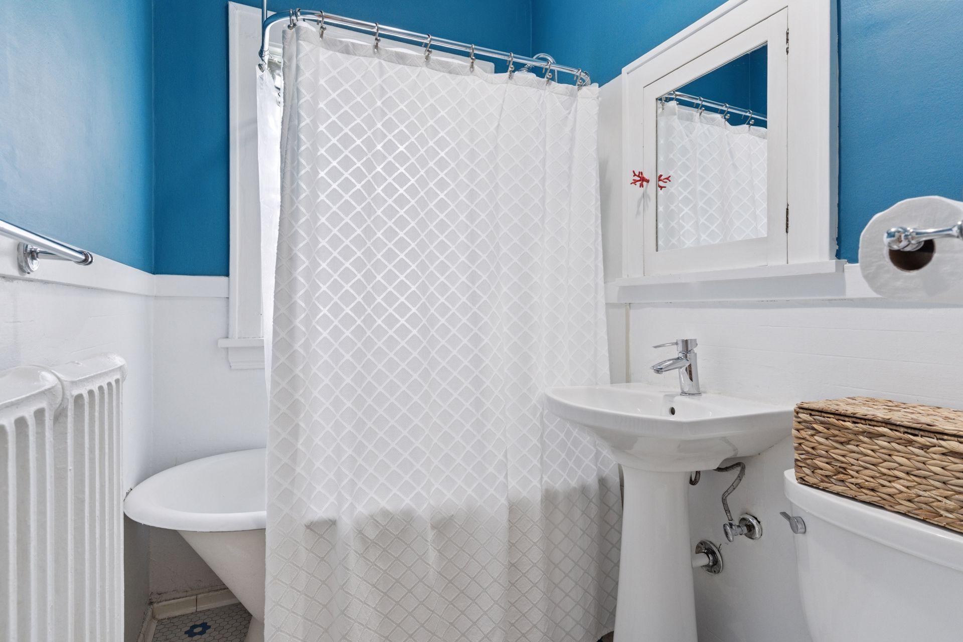 Well appointed bathroom with clawfoot tub/shower, vintage tile, and glass block window