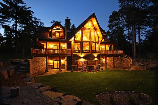 Twilight photo looking at the home from the elevated fire pit area