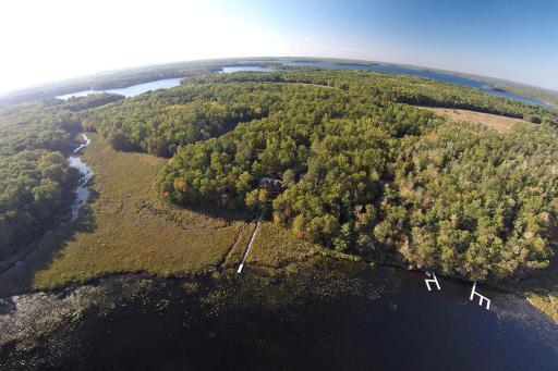 Aerial drone photo from above the lake looking towards the home and the 40 acres