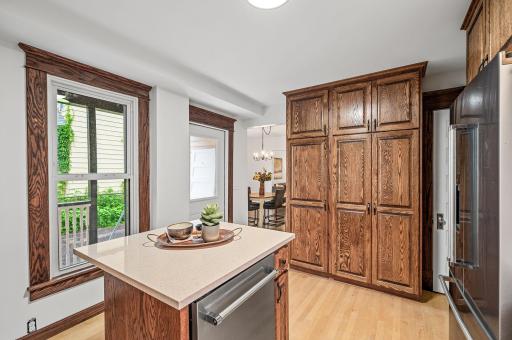 The kitchen boasts rich wooden cabinetry with new on-trend hardware, updated backsplash, and sleek quartz countertops.