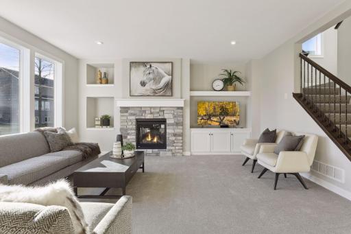 The living room on the main floor has a beautiful gas fireplace and wall built-ins. (Pic of a previous model)