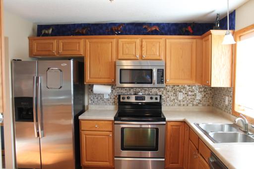 Stainless steel appliances to enjoy wonderful meals. Window in front of the sink let's in a lot of natural light. Tiled backsplash really makes the cabinets sparkle.