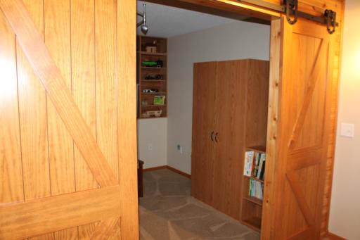 This is a Bonus room. The natural cedar plank accent wall and sliding barn doors really invite you.